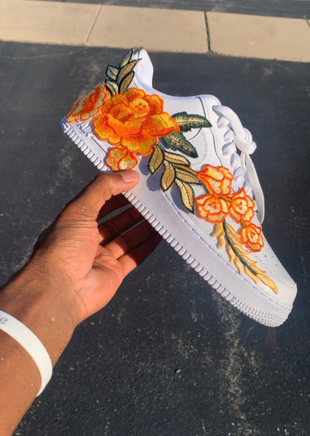 White sneaker with orange floral embroidery with hard painted orange bottoms 