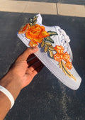 White sneaker with orange floral embroidery with hard painted orange bottoms 