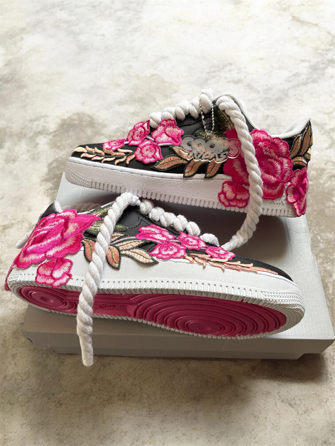Custom Pair of black and white af1 sneakers with pink floral embroidery. Hard pink bottoms for men and women 